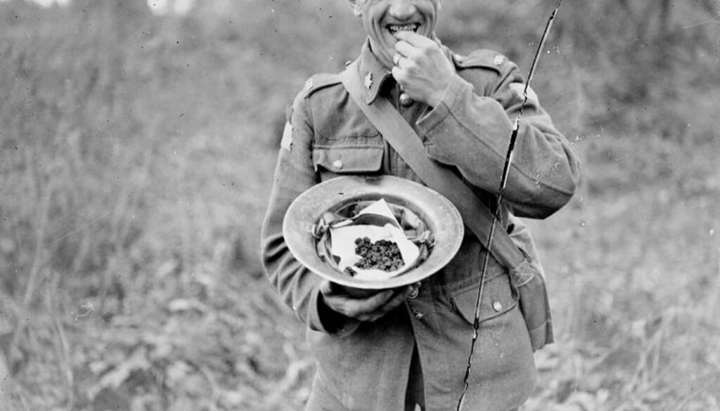 269_A Canadian enjoying blackberries which he had just gathered in Bourlon Wood. Advance East of Arras. October, 1918.